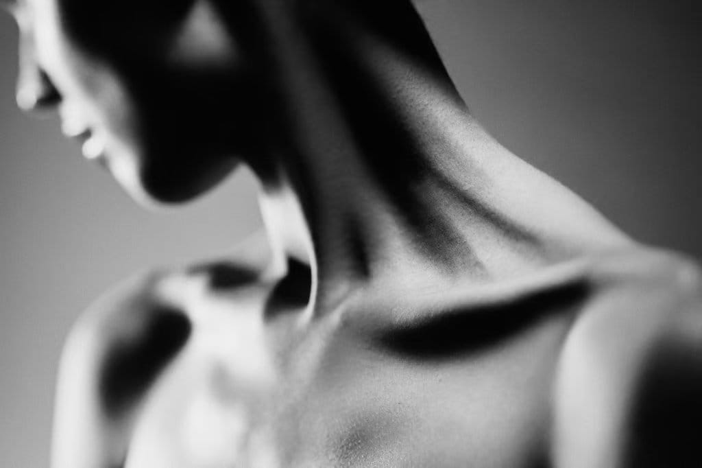 Black-and-white close-up of a woman's neck and shoulder